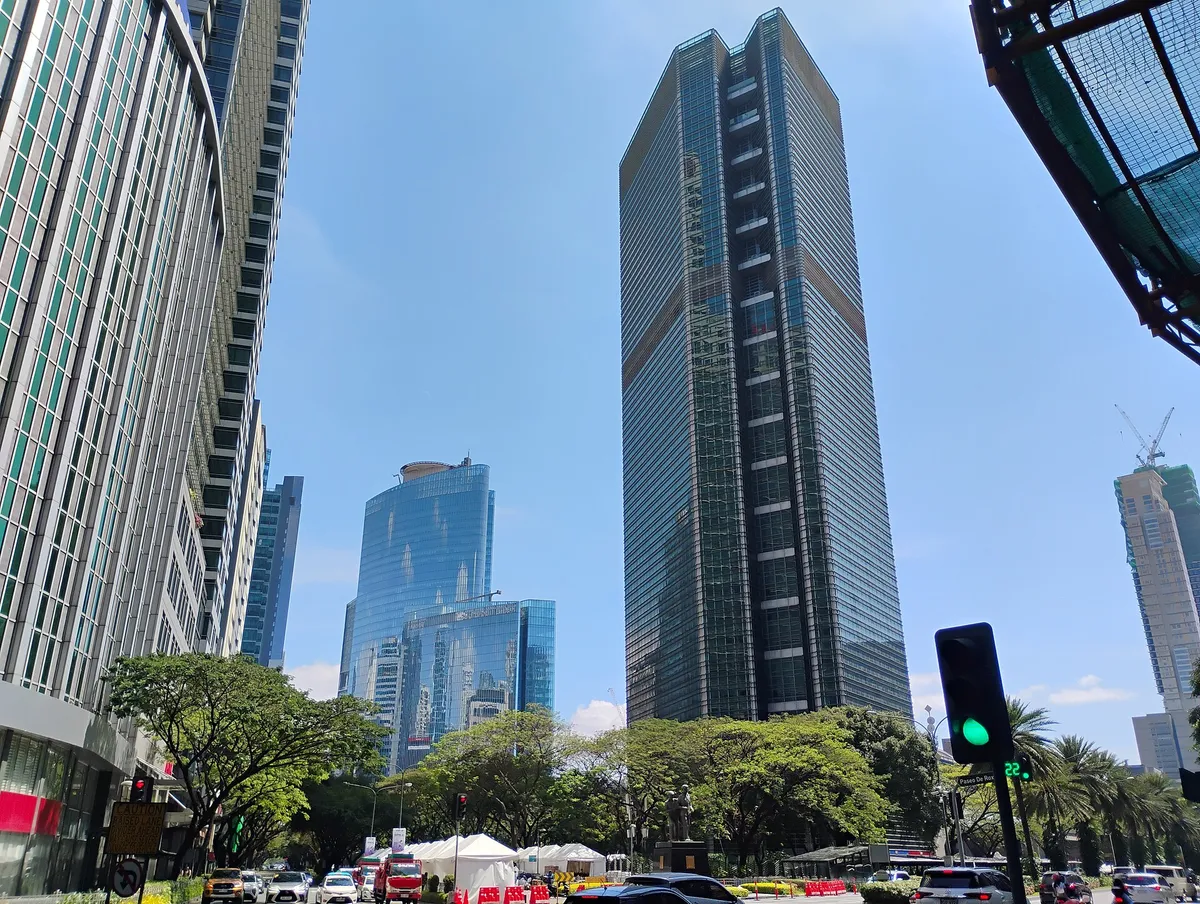 Glass office towers near Ayala Triangle in Makati's central business district, Metro Manila, on a clear day