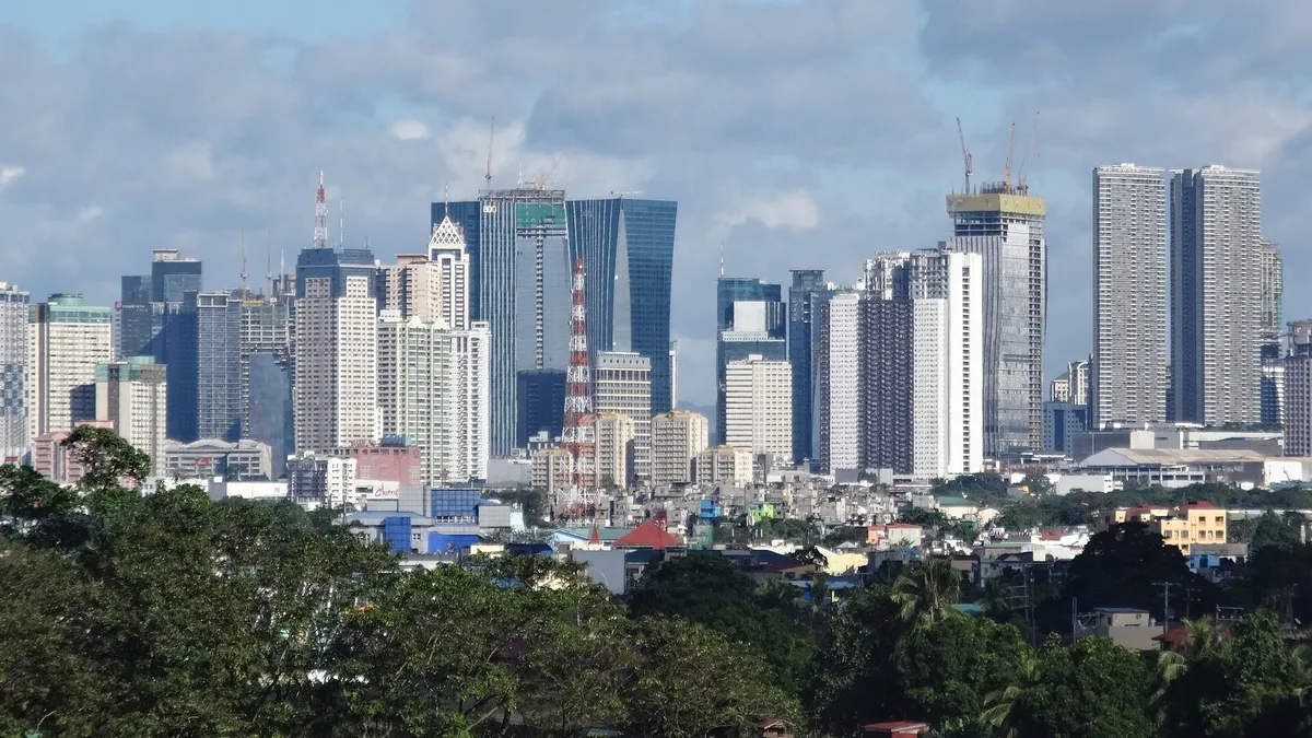 Ortigas Center skyline with condominium and office towers under a partly cloudy daytime sky, Metro Manila