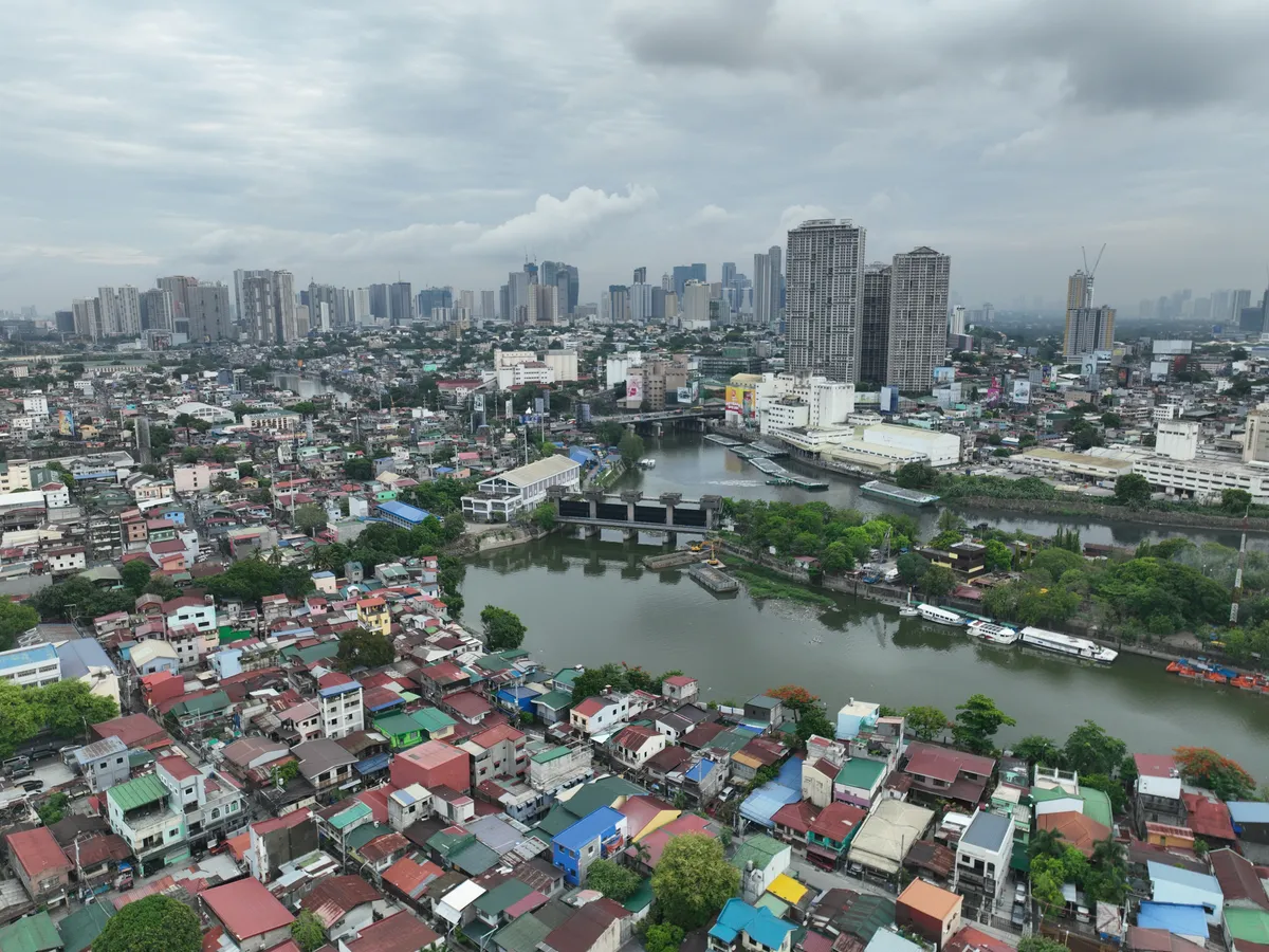 Pasig River flowing past residential towers in Bagong Ilog with the Ortigas skyline in the distance